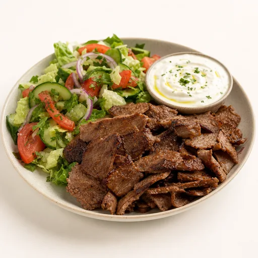 Plato de shawarma de carne sin pan con ensalada y salsa de yogur o tahini